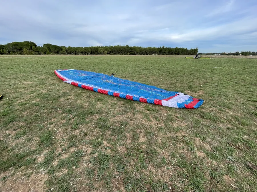 La voile de paramoteur étalée sur le terrain de décollage avant un vol